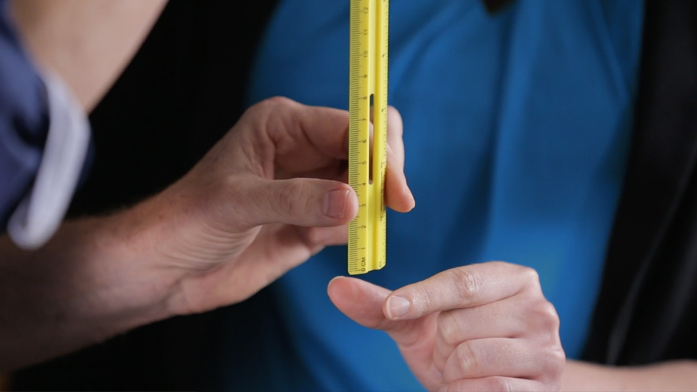 Two hands hold a ruler